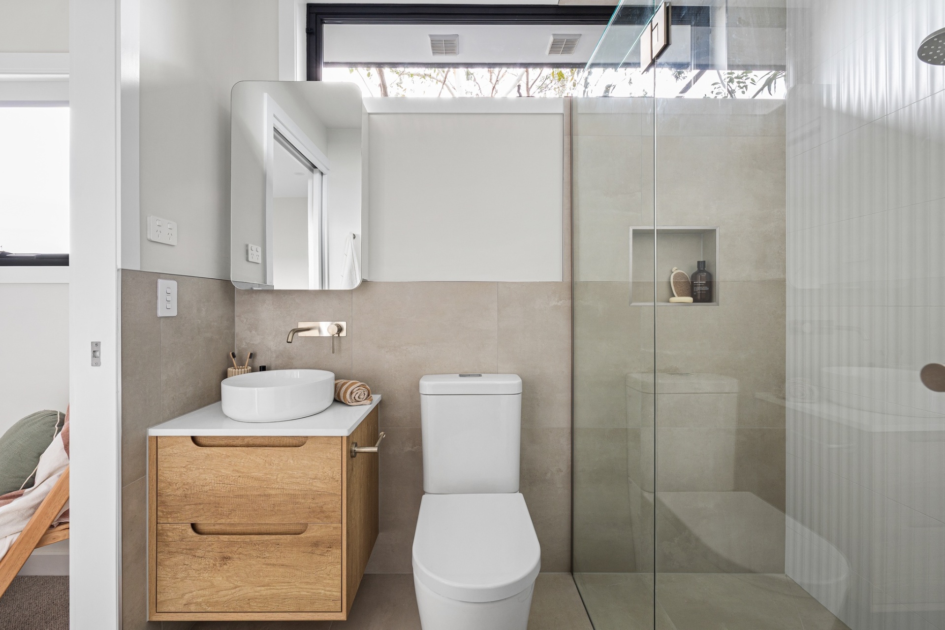 Ensuite with timber vanity, stone-look tile and walk-in shower